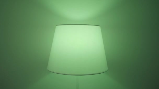 Gros plan d'une applique clignotant et changeant la couleur de la lumière à l'intérieur. L'action. Une applique avec différentes lumières créant une ambiance de fête ou de discothèque. — Video