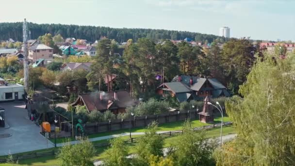 Beautiful small village with brick cottages located in ecological place. Video. Aerial view of modern village houses surrounded by forest on a summer day. — Stock Video