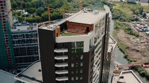 屋上にテラスと緑の芝生とビジネスクラスの新しい近代的なマルチ階建ての建物の空中ビュー。ビデオだ。新しい住宅団地の建設現場. — ストック写真