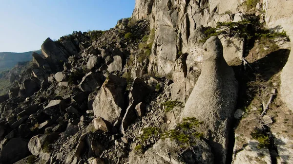 山の岩の間の極端な飛行。撃たれた。山の斜面の岩の層での高速飛行。緑の山の岩の斜面にウイングスーツのように飛ぶ — ストック写真