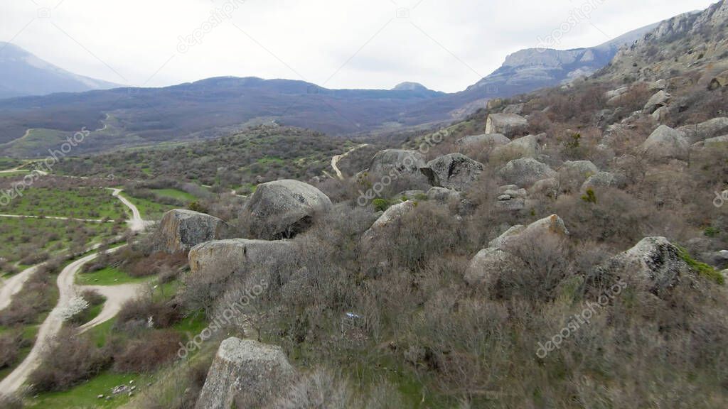 Boulders at foot of mountain. Shot. Drone view of extreme flight over boulders and rocks on mountain slopes. Natural destruction of mountains in form of landslides and boulders at foot