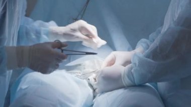 Cerrahlar dikiş atar. Başla. Anestezi altında hastaya cerrahi dikiş atıyorum. Cerrahlar profesyonel ve dikkatli bir şekilde ciddi bir ameliyattan sonra dikiş atarlar.