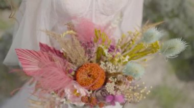 Bir gelin buketi. Başla. Tarz sahibi gelinin ellerinde alışılmadık bir buket yabani çiçek. Gelin için eşsiz bir buket yabani çiçek.