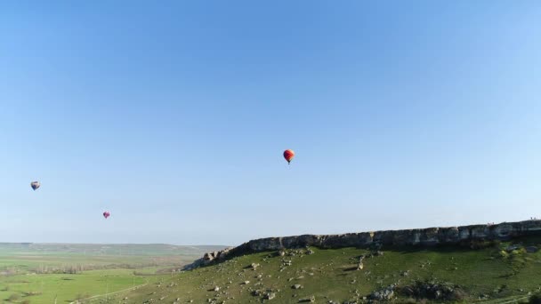 Vista inferior de globos de aire de colores que se elevan en el cielo sobre el prado de Geen. Le dispararon. Explorando la naturaleza desde una vista de pájaro. — Vídeos de Stock