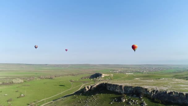 Des montgolfières dans le ciel au-dessus du champ à la campagne. Fusillade. Vue aérienne des aérostats voler au-dessus de la prairie d'été. — Video