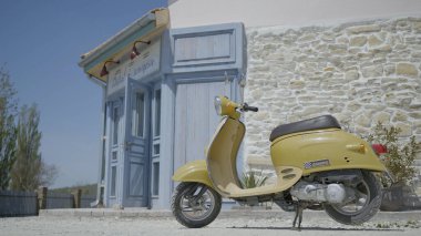 İtalyan caddesinin arka planında Retro Scooter. Başla. Sıcak yaz gününde Avrupa caddesinde klasik sarı scooter. Scooterlı Avrupa caddesinde şehir manzarası