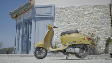 İtalyan caddesinin arka planında Retro Scooter. Başla. Sıcak yaz gününde Avrupa caddesinde klasik sarı scooter. Scooterlı Avrupa caddesinde şehir manzarası