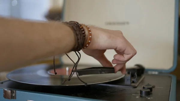 Primer plano de la mano poniendo récord en vinilo jugador. Acción. Man pone un disco vintage en el moderno y elegante tocadiscos. Hermoso modelo de tocadiscos vintage — Foto de Stock