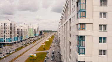 Modern konut binalarının ve şehir caddelerinin hava manzarası. Video kaydı. Bulutlu arka planda yeni yapılmış renkli evler.