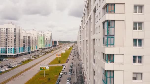 Légi kilátás egy modern lakóépületekre és egy városi utcára autóval. Videó. Újonnan épített színes házak felhős ég háttér. — Stock videók