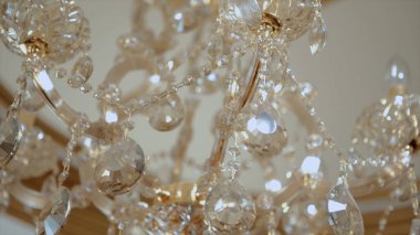 Binanın tavanında kristal olan lüks bir avize. Video kaydı. Altın avizenin alttaki görüntüsü, yapay elmaslar, iç mekan ayrıntıları..