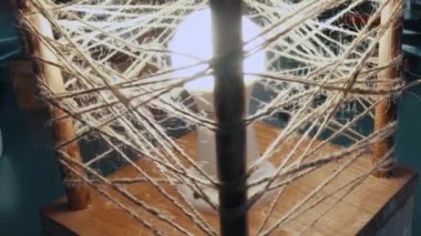 El yapımı dekoratif lambayı ampulle kapat. Video kaydı. Ahşap lamba çerçevesi sicim halatıyla sarılmış..