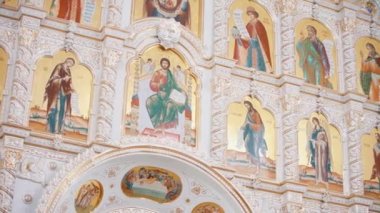 Iconostasis bir ortodoks kilisesinin içinde. Video kaydı. Azizlerin yüzlerine sahip simgelerin alt görüntüsü, din kavramı, kilisenin içindeki iç ayrıntılar..