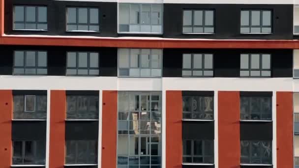 Vista aérea del nuevo edificio moderno, colorido, de gran altura, concepto de urbanización y arquitectura. Vídeo. Casa residencial naranja y negra de varios pisos. — Vídeo de stock