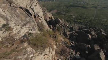 Dağ sırasının hava manzarası mavi bulutlu gökyüzü. Vuruldu. İnanılmaz kaya oluşumları ve yeşil yamaç, doğanın güzelliği..