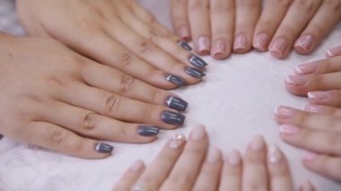 Beyaz masa arkaplanındaki kadın ellerini kapat. Video kaydı. Yeni manikür, Fransız ve çizgili tasarımın tanıtımı.
