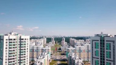 Gökyüzü arka planında güneşli caddeleri ve yüksek binaları olan büyük bir şehir manzarası. Video kaydı. Güzel renkli şehir alanı, kentleşme kavramı.