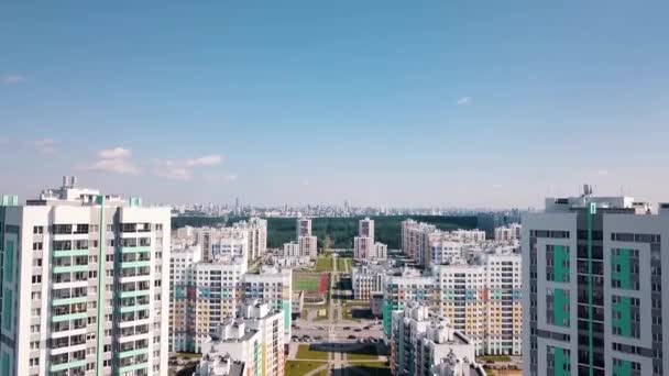 Вид с воздуха на большой район города с солнечными улицами и высотными жилыми зданиями на голубом фоне неба. Видео. Красивый красочный район города, концепция урбанизации. — стоковое видео