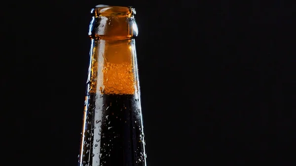 Close up of a hand opening a glass bottle. Video. Alcoholic drink isolated on black background, concept of party. — Stock Photo, Image