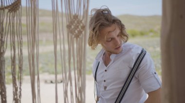 Gömlekli çekici adam köyde poz veriyor. Başla. Erkek model kır evinde gömlekle poz veriyor. Çiftlikteki fotoğraf çekiminde tişörtlü seksi adam.