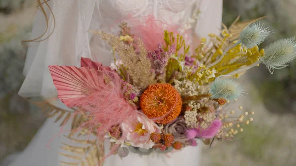 Γαμήλια ανθοδέσμη πεδίου της νύφης. Πάμε. Ασυνήθιστο μπουκέτο από άγρια λουλούδια στα χέρια της κομψής νύφης. Μοναδικό μπουκέτο από αγριολούλουδα για νύφη — Φωτογραφία Αρχείου