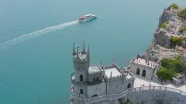 Dik uçurumun kenarındaki kalenin üst manzarası. Başla. Güzel beyaz kale mavi denizin yanındaki kayalık uçurumun üzerinde yer almaktadır. Kırım 'da Yuva Şatosu' nu Kırlangıç Kırlangıcı