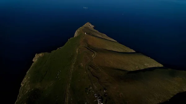 Εναέρια ενός παράκτιου πράσινου λόφου και ένα σκούρο μπλε ήρεμο Ατλαντικό ωκεανό, Sao Jorge νησί, Αζόρες, Πορτογαλία. Πυροβολήθηκε. Εκπληκτικό βουνό που καλύπτεται από πράσινο λιβάδι και έναν όμορφο ωκεανό. — Φωτογραφία Αρχείου