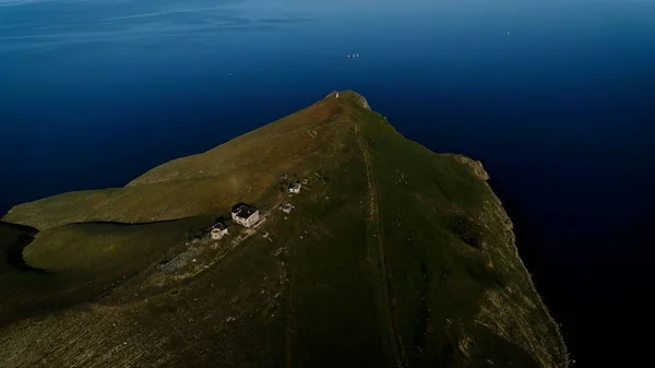 Antenne eines grünen Hügels an der Küste und eines dunkelblauen, ruhigen Atlantiks, Insel Sao Jorge, Azoren, Portugal. Schuss. Atemberaubender Berg mit grünen Wiesen und einem wunderschönen Meer. — Stockfoto