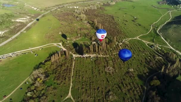 法国农村地区天空中彩色气球的空中景观。开枪了飞过树木、灌木丛、绿地和停车场. — 图库视频影像
