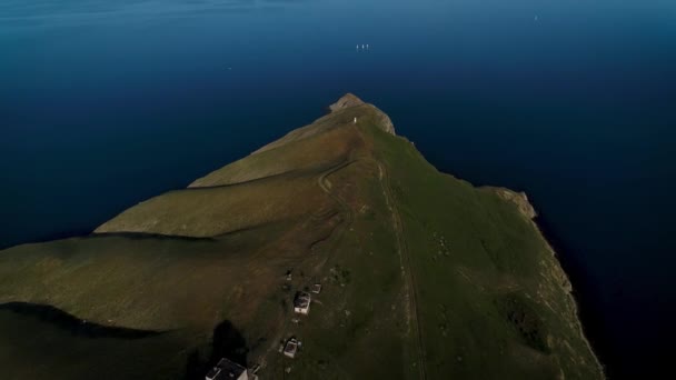 Antenne eines grünen Hügels an der Küste und eines dunkelblauen, ruhigen Atlantiks, Insel Sao Jorge, Azoren, Portugal. Schuss. Atemberaubender Berg mit grünen Wiesen und einem wunderschönen Meer. — Stockvideo