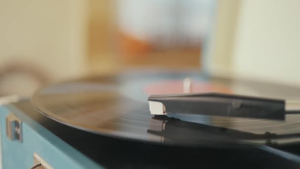 Tourne-disque en vinyle avec l'aiguille sur la plaque tournante. L'action. Gros plan du lecteur de vinyle rétro de travail sur le fond intérieur de la maison. — Video
