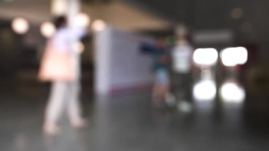 Alışveriş merkezinde yürüyen insanlardan oluşan odaklanmış bir kalabalık. HDR. Yürüyen kadın ve erkeklerle iş merkezinin görüşü bulanık..