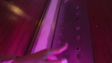 Sarhoş bir kadının eski bir asansörde yanıp sönen ışıkları olan tüm düğmelere basmasını çek. Stok görüntüleri. Alkol ya da uyuşturucu etkisi altında asansörün tehlikeli kullanımı.