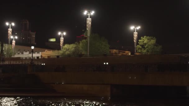 A barragem da cidade de Ekaterinburg com lanternas e o rio Iset, Rússia. Imagens de stock. Uma ponte acima do rive na noite no fundo preto do céu. — Vídeo de Stock