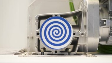 Hipnotik etki yaratan parlak mavi spiral ile dönen beyaz daireyi kapatın. HDR. Otomatik dönen hipnotik çemberli olağandışı bir robot..