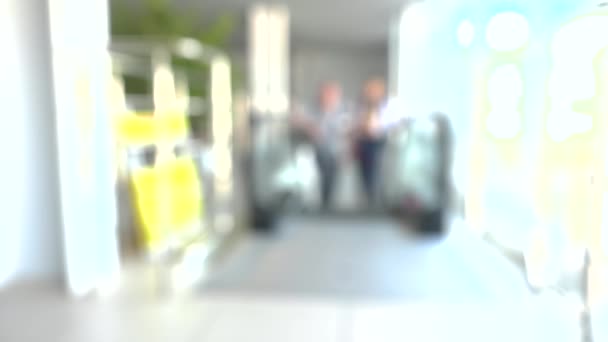 Fondo borroso con gente subiendo en escaleras mecánicas. HDR. Una pareja fue al aeropuerto en escaleras mecánicas. Luces brillantes y imagen borrosa de la pareja en el aeropuerto — Vídeo de stock