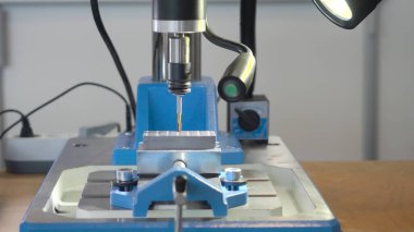 Matkaplı küçük bir makine. HDR. Nokta sondajı için yüksek hassasiyetle ışık alan bir masaüstü makinesi. Matkap ve lambalı modern masaüstü makinesi