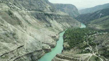 Kayalık arazide akan dar bir dağ nehri. Başla. Sabahları sisli bir dağda uzanan turkuaz sakin bir nehrin havadan görünüşü..