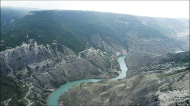 Kayalık arazide akan dar bir dağ nehri. Başla. Sabahları sisli bir dağda uzanan turkuaz sakin bir nehrin havadan görünüşü..
