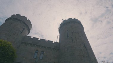 Ortaçağ şatosunun alt manzarası. Başla. Güneşli gökyüzünün arka planında büyük bir taş kale. Zamanımıza kadar korunmuş güzel bir ortaçağ kalesi.