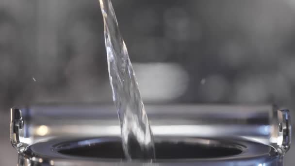 Nahaufnahme von Wasser, das in einen Metallkessel gegossen wird. Handeln. In einen Wasserkocher wird sauberes Wasser gegossen. Wasser wird in Metallteekanne für Tee gegossen — Stockvideo
