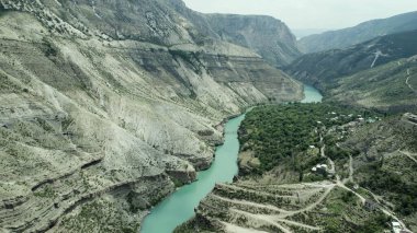 Kayalık arazide akan dar bir dağ nehri. Başla. Sabahları sisli bir dağda uzanan turkuaz sakin bir nehrin havadan görünüşü..