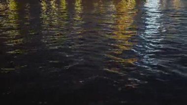 Kanalda fenerlerin yansıması olan güzel bir su. Başla. Kanal suyundaki güzel gece ışıklarının yansıması. Şehir ışıklarının güzel yansımasıyla kanal boyunca yüzmek