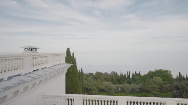 Вид з готелів на балкон до моря. Дія. Дах старого готелю з колонами на тлі моря. Вид на море і рослинність з даху готелю — стокове відео
