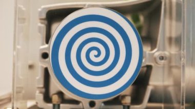 Hipnotik etki yaratan parlak mavi spiral ile dönen beyaz daireyi kapatın. HDR. Otomatik dönen hipnotik çemberli olağandışı bir robot..