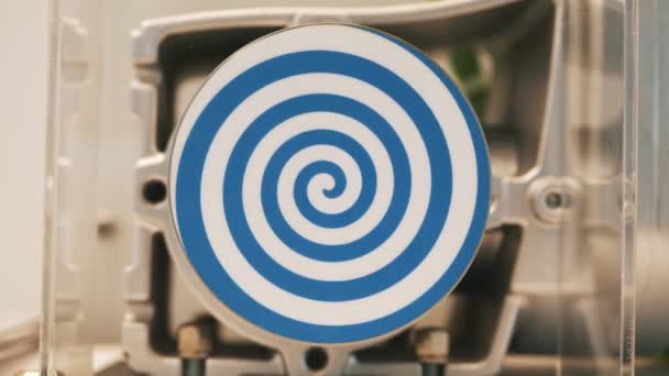 Primer plano del círculo plano blanco giratorio con espiral azul brillante que crea efecto hipnótico. HDR. Robot inusual con círculo hipnótico giratorio automatizado. — Vídeos de Stock