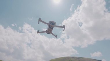 Dağların ve gökyüzünün arka planında uçan bir kuadkopter. Başla. Seyahat ederken ateş etmek için profesyonel bir kuadkopter. Quadcopter yükselir ve dağ manzaralarının fotoğraflarını çeker.