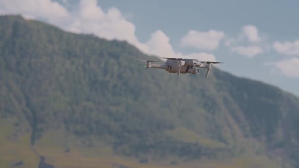 Quadcopter fliegt auf Hintergrund von Bergen. Handeln. Quadcopter fliegt und schießt schöne Berglandschaften. Quadrocopter fotografiert grünes Gebirgstal — Stockvideo