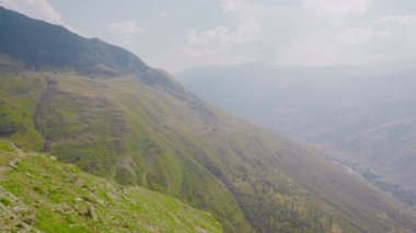 Puslu taşlı yeşil dağ vadisi. Başla. Sisli dağlardaki vadi manzarası. Güneşli günde Dağ Vadisi 'nde sabah sisi