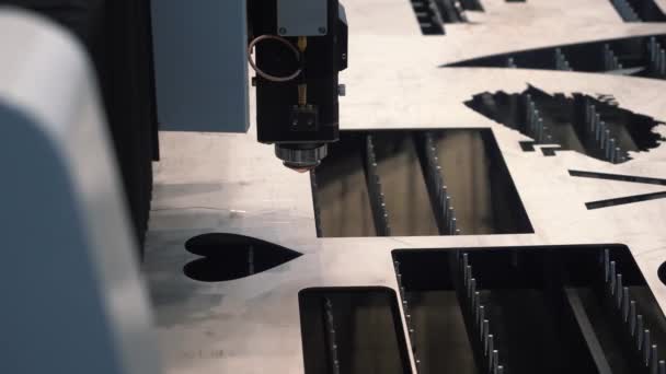 Παρουσίαση βιομηχανικού εξοπλισμού στην τεχνολογική έκθεση. HDR. Λέιζερ μηχάνημα κοπής μετάλλων δημιουργώντας μια τρύπα σε σχήμα καρδιάς σε ένα επίπεδο φύλλο από μεταλλικό υλικό χάλυβα. — Αρχείο Βίντεο